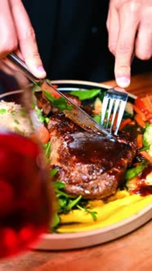 Cutting Steak with Vegetables on a Plate