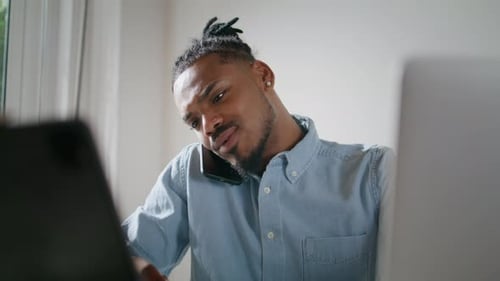 Busy Freelancer Talking Phone in Light Office Closeup. African American Man Working