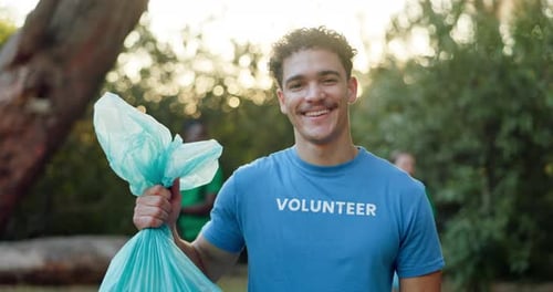 Smiling Volunteer Holding Trash Bag Outdoors