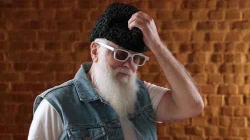 Senior Man Puts on Hat and Smiles