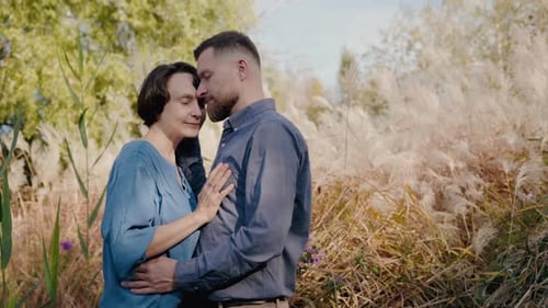 Affectionate Couple Embracing in a Grassy Field