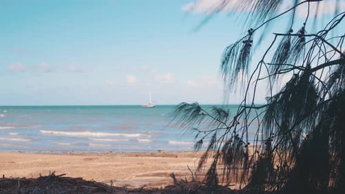 A small boat floats in beautiful, blue, tropicic waters under a warm, sunny sky just off the coast o