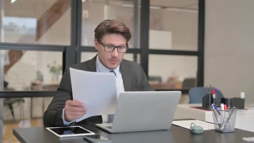 Excited Businessman With Laptop in Modern Office