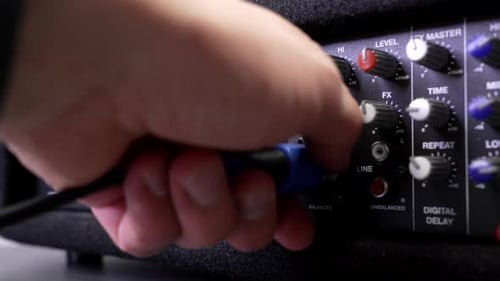 Hand Plug Cable Into Audio Mixing Board