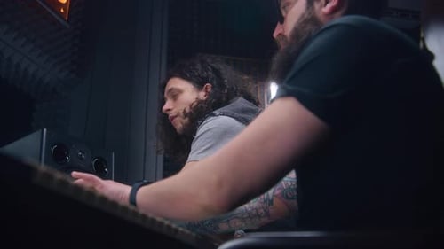 Producer and Musician Listen New Track in Recording Studio