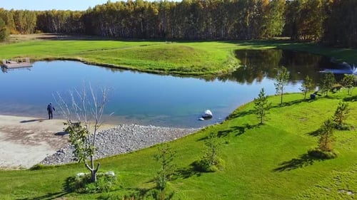 A Serene and Tranquil Pond Featuring a Beautiful Fountain Amidst a Lush Green Landscape