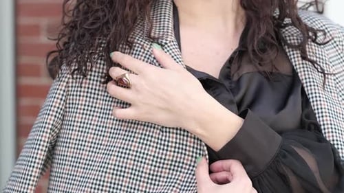 Asian Female Touches Her Chic Jacket Showcasing Intricate Pattern and Elegant Ring Blending