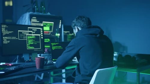 Ein fokussierter Programmierer, der in einer schwach beleuchteten Cyberumgebung voller Technologie arbeitet