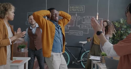 Grupo diversificado de funcionários dançando comemorando um trabalho bem-sucedido curtindo uma festa no escritório