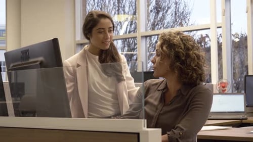 Two Women Talking In Office And Looking At Computer