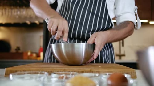 Person Mixing Ingredients in a Kitchen Bowl