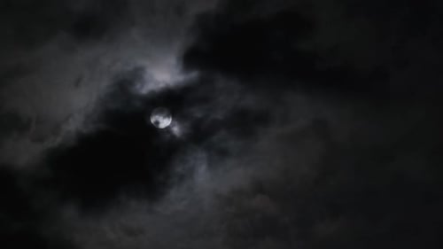 Moon Through Dark Clouds at Night