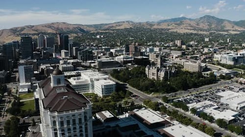 Drone shot of The Grand American Hotel sitting amidst Salt Lake City's downtown streets.