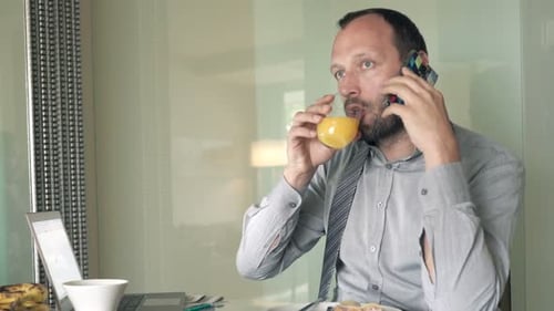 Man Talking on Phone During Breakfast at Home