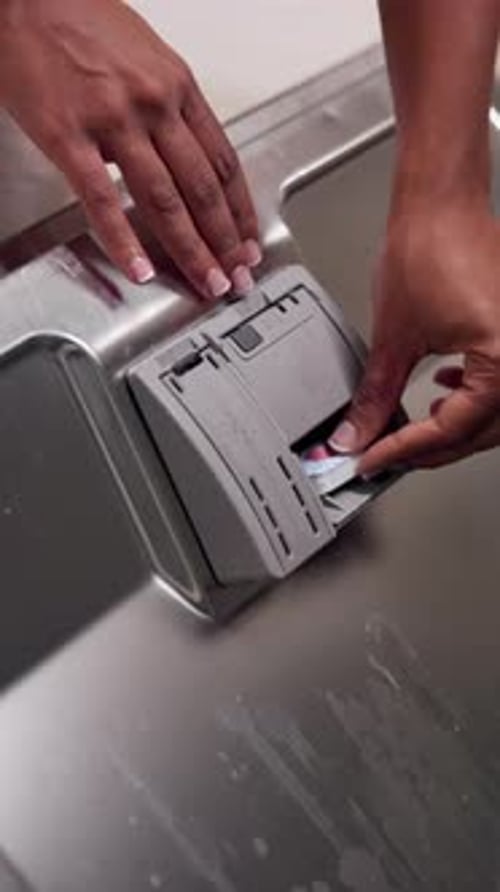 Dishwasher Pod Placed Into Gray Dishwasher