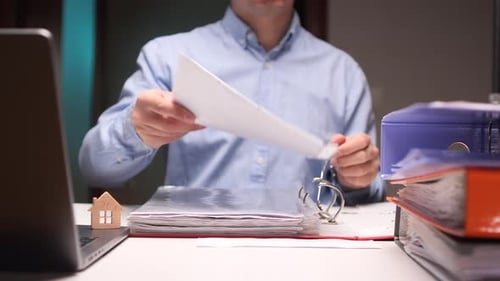 Office Clerk Reading Documents and Working Late at Night
