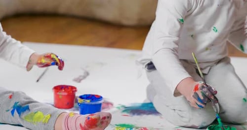 Two Children Painting With Colorful Paints Indoors