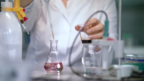 Chemical Reaction In Flask. Female Scientist Carrying Out Scientific Research. Scientist Woman Dr...