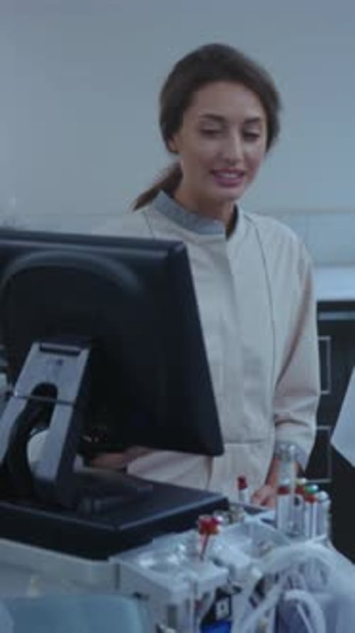 Medical Technician Attentively Operating Dialysis Equipment While Recording Essential Patient