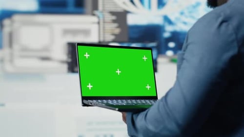 Black Engineer Works on Binary Code with Chroma Key on Laptop