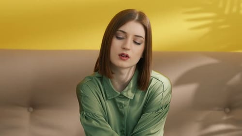 Pensive Woman with Brown Hair Thinking on Sofa