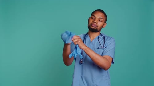 Male Nurse Putting on Rubber Gloves Preparing for Surgery