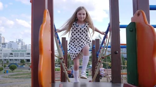 Little Girl Playing in the Playground in Summer