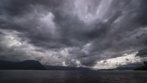 Dark menacing stormy clouds move fast above the fjord.