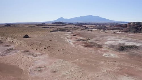 An aerial drone shot of an RV off-road driving through the Utah desert on an American roadtrip
