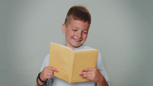 Boy Happily Reads a Book Indoors