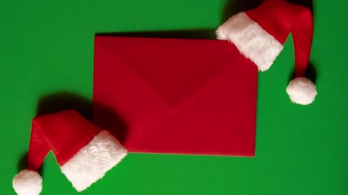 Zoom in Out Santa Hat with Empty Paper Card Note Envelope on Green Background Copy Space for your