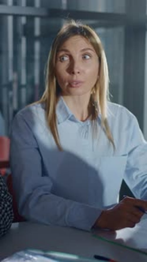 Focused Young Professional Woman in Light Blue Shirt Participating in Office Meeting Listening