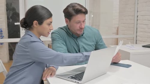 Woman Typing on Laptop and Talking with Man