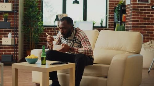 Man Eating Noodles in his Living Room