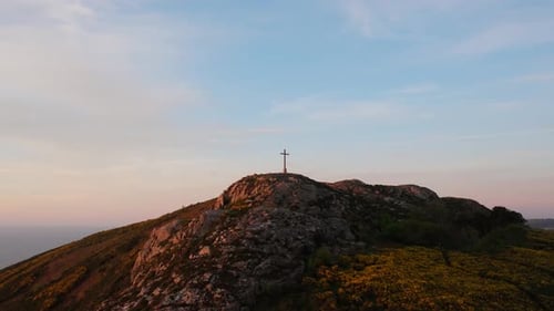 Cross on Rocky Hill at Dawn with Ocean in View