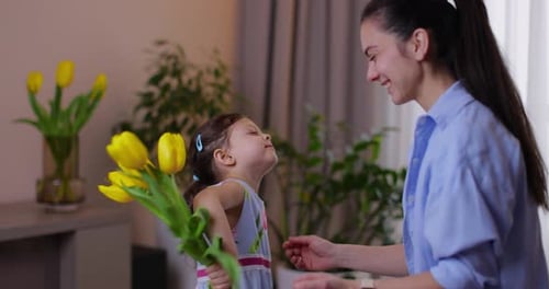 Child Giving Flowers to Woman in Living Room