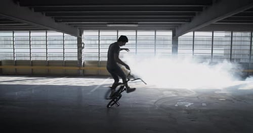 Young Adult Performing BMX Trick in Parking Garage