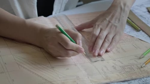 Architect using ruler and pencil to make blueprints on old paper. Engineer works with blueprints