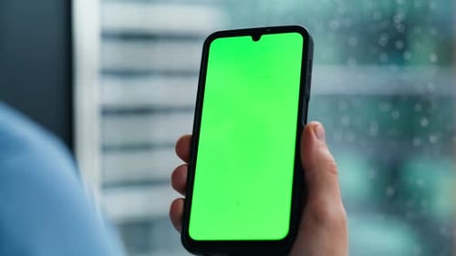 Smartphone with Green Screen Being Used Indoors