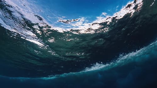 Vue sous-marine de la vague océanique qui se déchire aux Maldives avec beaucoup de mousse et de bulles