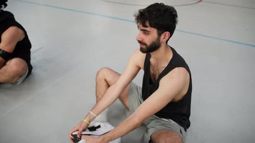 Athletes Sitting On The Ground In Indoor Basketball Court