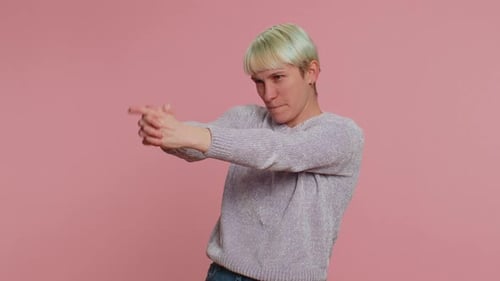 Frau zeigt mit Fingerpistolengeste herum und sieht selbstbewusst aus, trifft Entscheidung Schießerei