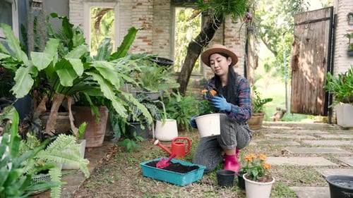 Woman Gardening Orange Flowers in a Lush Garden