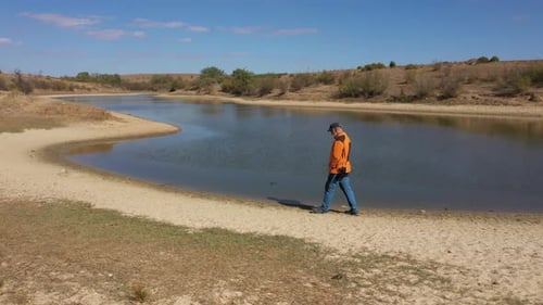 Homme marchant pensivement au bord du lac