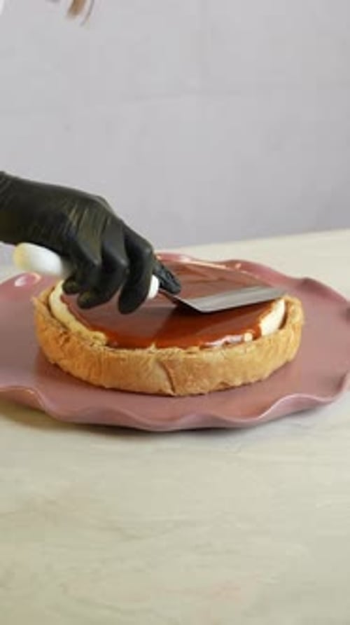 A chief put a caramel sauce to a cake, close up shot, insert shot