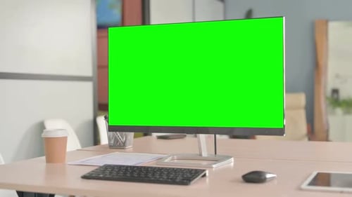 Desktop with Green Screen on Table in Office