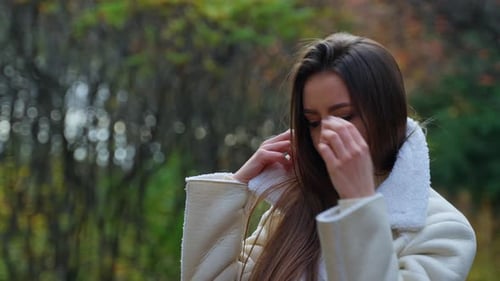Fashionable Woman Adjusts Jacket in Nature