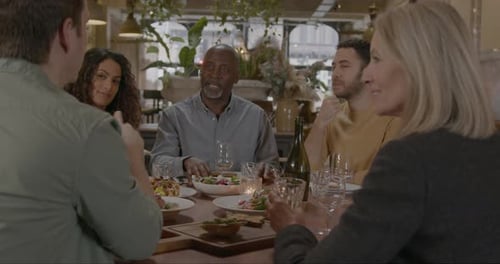 Family and Friends Enjoying Dinner in Restaurant Together