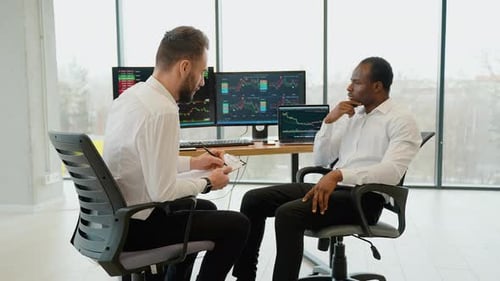 Financial Professionals Discuss Stock Market Data in Bright Office