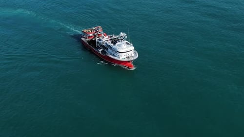 A Small Fishing Vessel Sails to the Port After Morning Fishing Aerial View